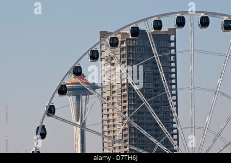 Stati Uniti d'America, WA, Seattle. Drammatica downtown waterfront include iconico lo Space Needle e il Seattle Grande Ruota Foto Stock