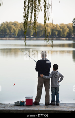 Nonno e nipote la pesca al largo di banchina sul lago Foto Stock