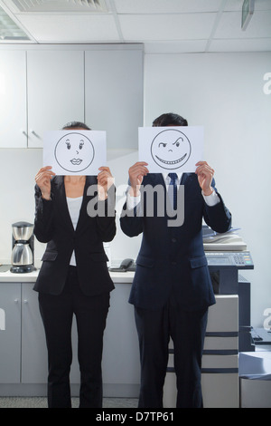 Businessman Holding volti felici su carta Foto Stock