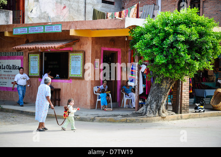 Donna anziana e toddler femmina di attraversare una via di San Pancho, Messico Foto Stock