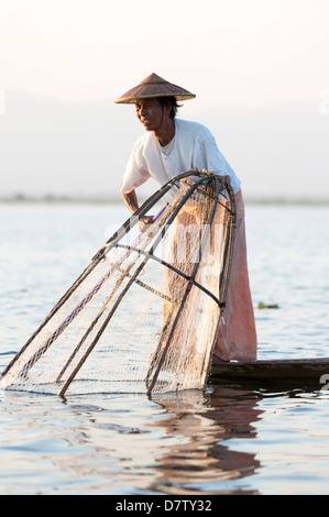 Gamba Intha canottaggio pescatori al tramonto sul Lago Inle, Lago Inle, Stato Shan, Birmania Foto Stock