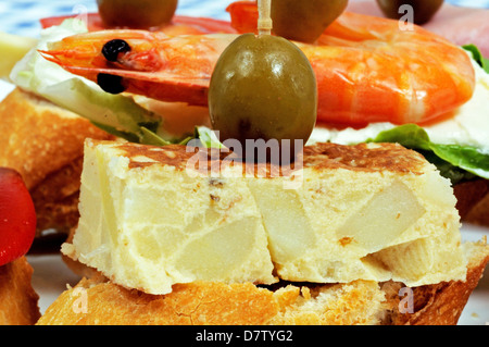 Spagnolo selezione di tapas, con frittata di patate di Spagna sormontato da un verde oliva e servite su crostini di pane in primo piano, Andalusia Foto Stock