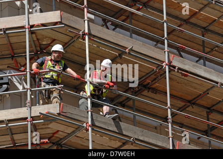 Londra, Inghilterra, Regno Unito. Operai guardando giù dai ponteggi Foto Stock