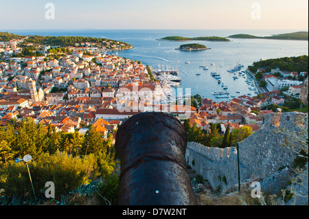 Fortezza di Hvar cannone e la citta di Hvar al tramonto preso dal Forte Spagnolo, Isola di Hvar costa dalmata, Adriatico, Croazia Foto Stock