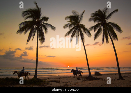 Cavalieri al tramonto, Playa Guiones surf beach, Nosara, Nicoya peninsula, provincia di Guanacaste, Costa Rica Foto Stock