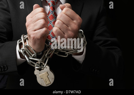 Close up businessmans mani legate in catene pesanti con lucchetto Foto Stock