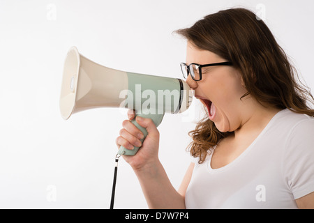 Un giovane brunette teenage ragazza caucasica gridando in un megafono bull-corno che indossano occhiali urla urlando regno unito Foto Stock