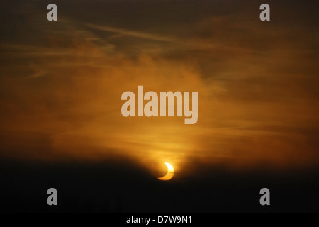 Eclissi Parziale di Sole visto attraverso la nebbia durante il sunrise Foto Stock