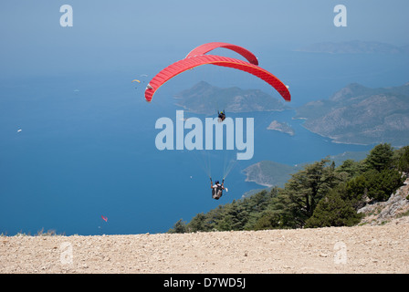 Parapendio in Oludeniz bird's eye Fethiye, Turchia. Vista sulle montagne e il mare blu, alberi. Andando verso il basso. Foto Stock