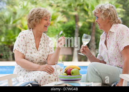 Le donne anziane gustando un bicchiere di vino bianco fresco Foto Stock