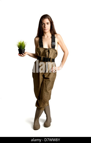 Ragazza in posa con un piccolo vaso con erba Foto Stock