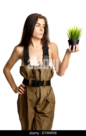 Ragazza in posa con un piccolo vaso con erba Foto Stock