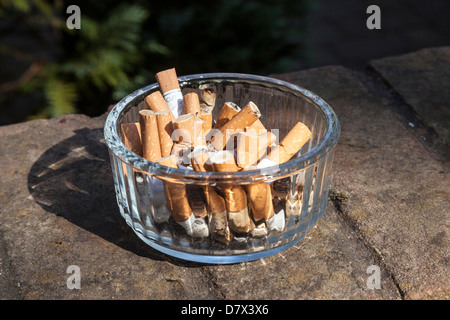 Mozziconi di sigarette nella ciotola posacenere Foto Stock