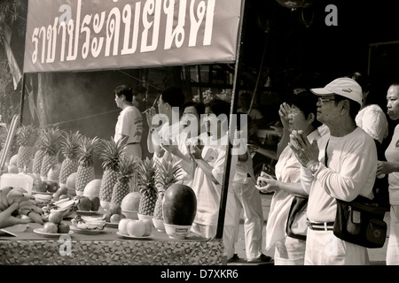 PHUKET, Tailandia 1 Ottobre 2011: gli spettatori a stare dietro un tavolo offerte stazione presso il Phuket annuale Festival vegetariano. Foto Stock