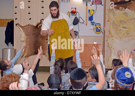 I figli piccoli di ottenere una lezione di come Torahs sono realizzati presso il Jewish il museo dei bambini in Crown Heights, Brooklyn, New York Foto Stock