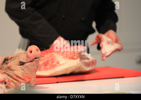Grand Designs Live 2013, uomo dimostrando come tagliare una costola di maiale Foto Stock