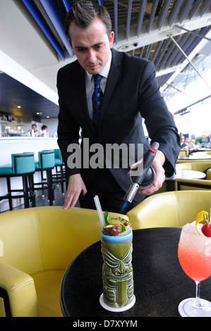 Illuminazione del barman un cocktail presso la Oxo Tower Bar, London, England, Regno Unito Foto Stock