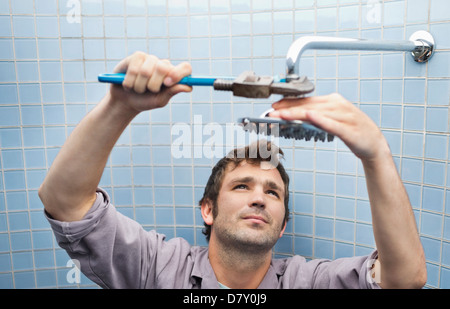 Plumber lavorando sulla testa di doccia nella stanza da bagno Foto Stock