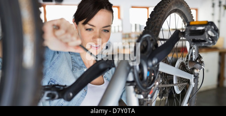 Donna al lavoro su bicicletta in negozio Foto Stock