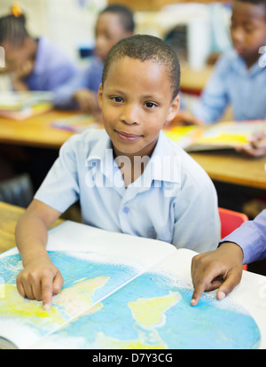 Gli studenti utilizzando la mappa del mondo in classe Foto Stock