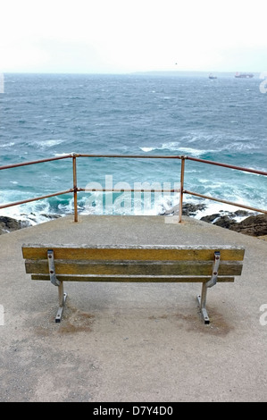 Un banco che si affaccia su un mare agitato in Falmouth, Cornwall, Regno Unito. Vista da Pendennis Point Foto Stock