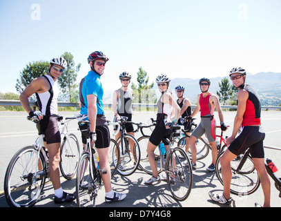 I ciclisti sorridente insieme sulla strada rurale Foto Stock