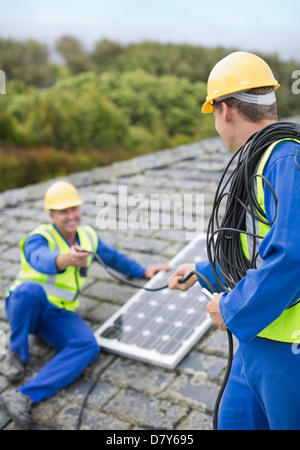Lavoratori installazione pannello solare sul tetto Foto Stock
