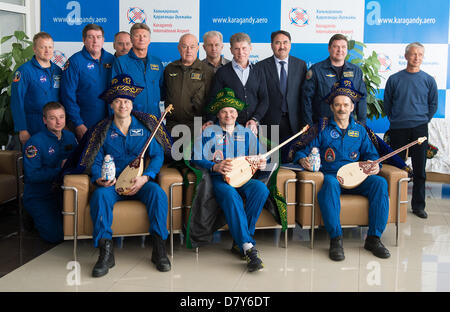 Agenzia Spaziale Canadese Expedition 35 Commander Chris Hadfield, destra,'agenzia Spaziale Federale Russa cosmonauta Romanenko romana, centro e astronauta della NASA Tom Marshburn con doni di tradizionale abito Kazakistan durante una cerimonia di benvenuto all aeroporto di Karaganda Maggio 14, 2013 in Kazakistan. Hadfield, Romanenko e Marshburn restituito da cinque mesi a bordo della Stazione spaziale internazionale dove sono serviti come membri della spedizione 34 e 35 equipaggi. Foto Stock