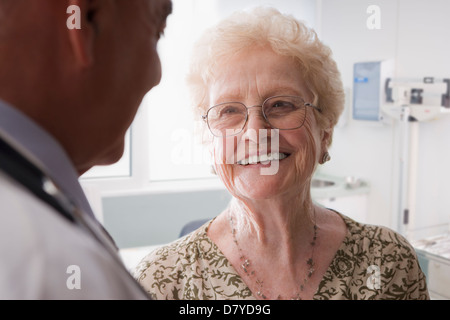 Medico di origine ispanica a parlare con pazienti anziani Foto Stock