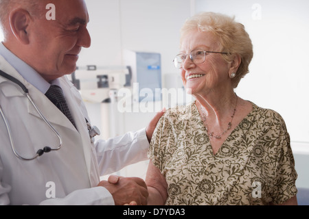 Medico di origine ispanica a parlare con pazienti anziani Foto Stock