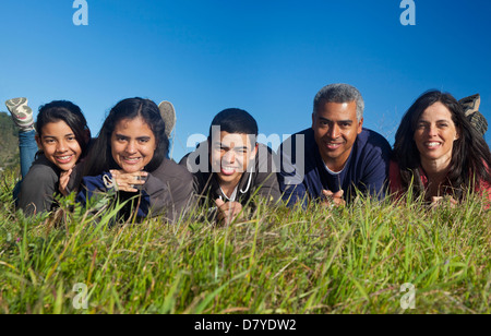 Famiglia di origine ispanica sorridente in erba Foto Stock