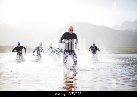 Triatleti emergenti dall'acqua Foto Stock