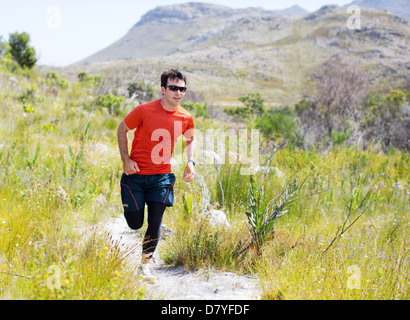 Uomo che corre sul tracciato sterrato Foto Stock