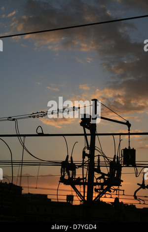 Treno di overhead di linee di alimentazione a roma Italia al tramonto Foto Stock