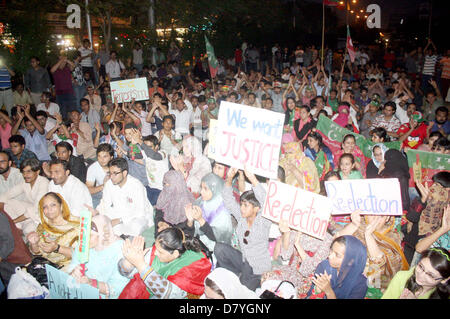 I sostenitori del Tehreek-e-Insaf (PTI) chant slogan contro presunti brogli nelle elezioni generali durante la manifestazione di protesta presso l' Università road a Karachi il mercoledì 15 maggio, 2013. Foto Stock