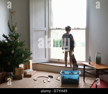 Ragazzo azienda calza di Natale in corrispondenza della finestra Foto Stock