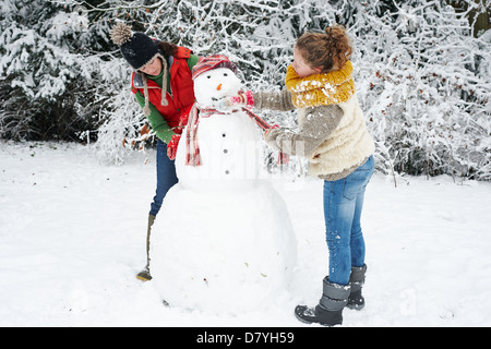 Madre e figlia rendendo pupazzo di neve Foto Stock