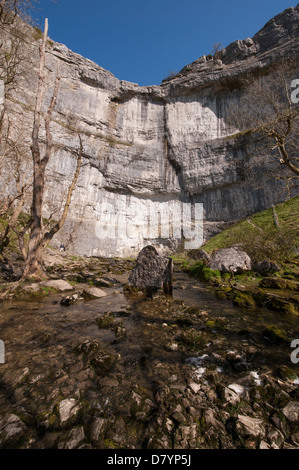 Sunny vista panoramica di acqua in vasca di tintura da Malham Cove sotto il cielo blu - enorme, a strapiombo, curvando roccia calcarea in splendide Yorkshire Dales, Inghilterra, GB, UK. Foto Stock