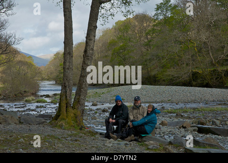 Tre escursionisti in appoggio sul fiume Derwent, in Borrowdale, Parco Nazionale del Distretto dei Laghi, Cumbria, England Regno Unito Foto Stock