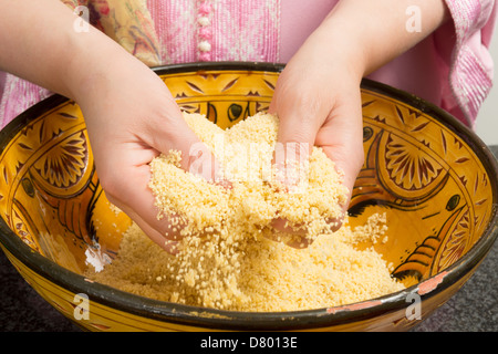 Marocchina tradizionale donna immigrati in Europa cucinare cuscus durante il Ramadan Foto Stock