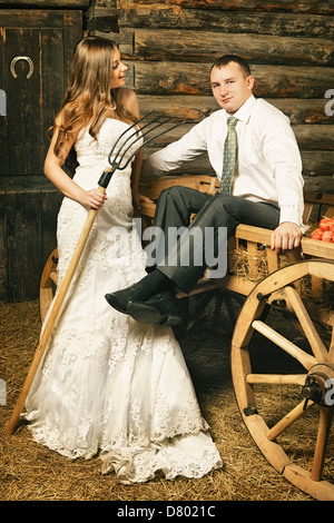 Affascinante la sposa e lo sposo in fienile al giorno di estate Foto Stock