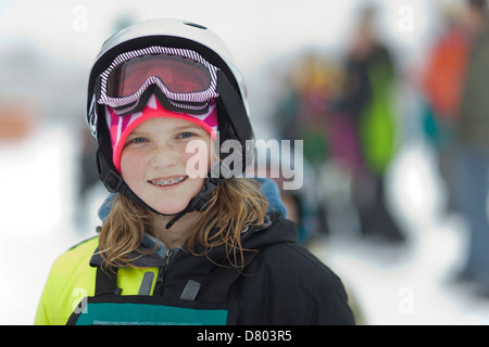 Ragazza caucasica indossando attrezzatura da sci nella neve Foto Stock