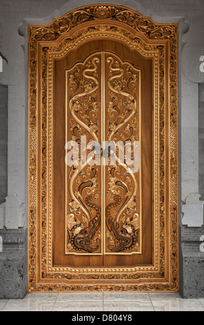 La porta di legno di un vecchio tempio coperti con intagli. Indonesia Bali Foto Stock