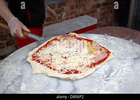 Uomo che fa la pizza che porta su una buccia circa per mettere in forno Foto Stock