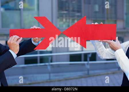 La gente di affari con due frecce rosse che puntano a ciascun altro Foto Stock