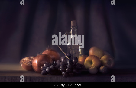 La frutta e la bottiglia sul tavolo Foto Stock