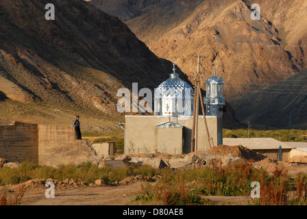 Un uomo vicino alla nuova costruzione moschea nel villaggio del Kirghizistan in montagna vicino la canzone Kul lago. Regione di Naryn, Kirghizistan Foto Stock