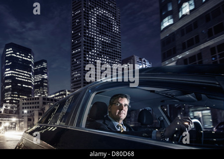 Imprenditore caucasica la guida su una strada di città Foto Stock