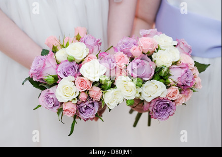Bridesmaids due bouquet di fiori sono di colore rosa e viola le rose Foto Stock