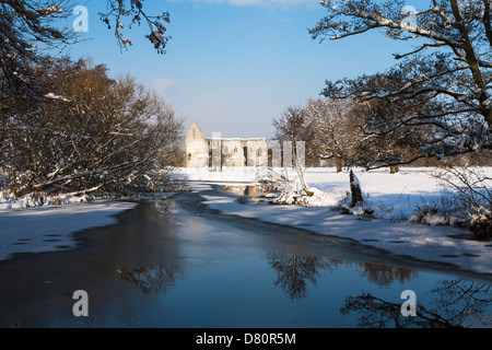 Newark Priory, sciolto da Enrico VIII, nella luce del sole nella neve con un cielo blu - Pyrford, Surrey, Inghilterra, con il fiume Wey Foto Stock